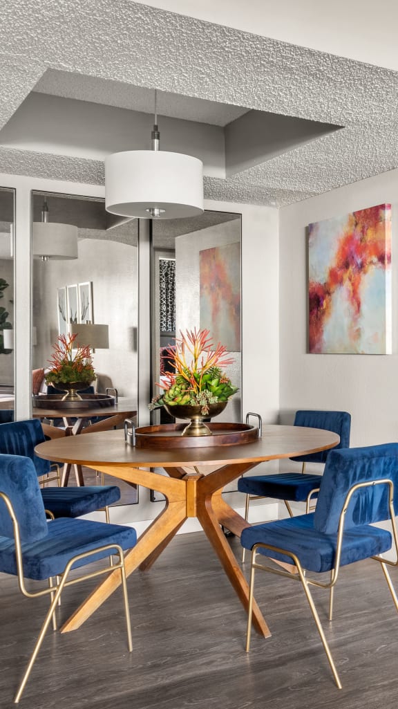 a dining area with a wooden table and blue chairs